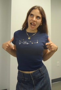 a woman wearing a blue t - shirt posing for the camera